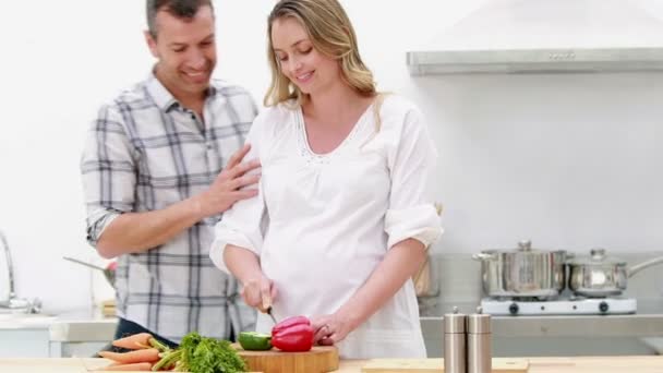 Zwangere vrouw maken een salade met haar echtgenoot — Stockvideo