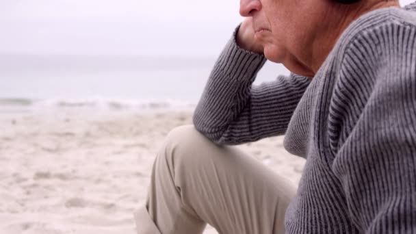 Задумчивый пенсионер слушает музыку — стоковое видео