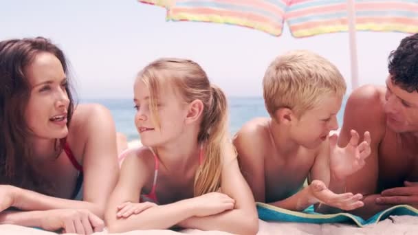 Family discussing on their towel — Stock Video