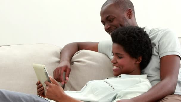 Пара використовує планшет на дивані — стокове відео