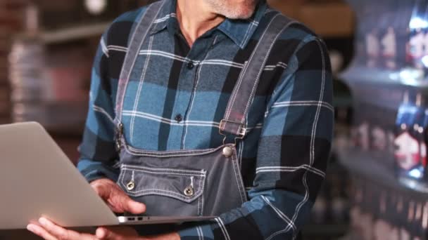 Trabalhador da cervejaria usando laptop para fazer inventário — Vídeo de Stock