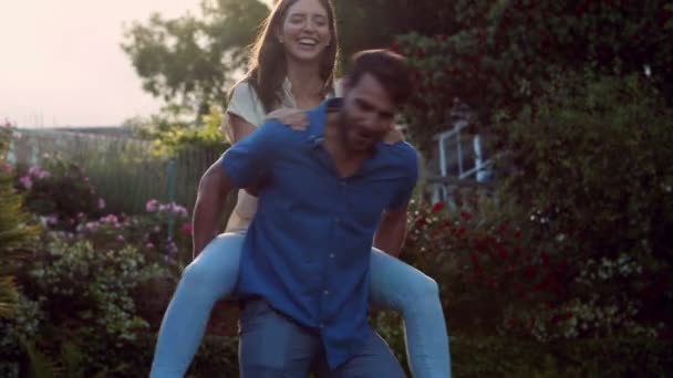 Hombre guapo dando cerdito de nuevo a su novia — Vídeos de Stock