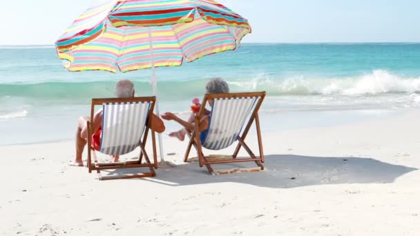 Jubilados pareja de ancianos tumbados en la tumbona mientras beben cócteles — Vídeos de Stock