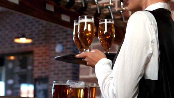 Barmaid souriante servant des verres de bière — Video