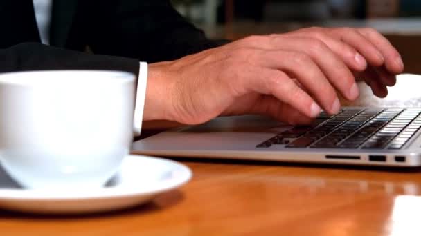 Businessman working on laptop while drinking coffee — Stock Video