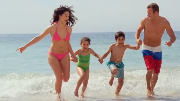 Familia feliz corriendo en el agua — Vídeo de stock