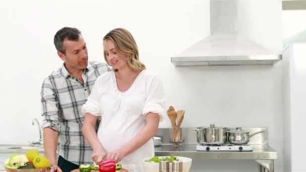 Zwangere vrouw maken een salade met haar echtgenoot — Stockvideo