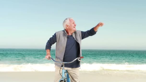 Viejo jubilado en bicicleta apuntando al cielo — Vídeo de stock