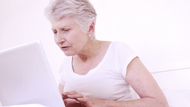 Sorrindo mulher idosa fazendo videochamada com laptop — Vídeo de Stock