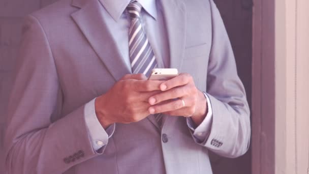 Lachende zakenman typen op zijn smartphone — Stockvideo