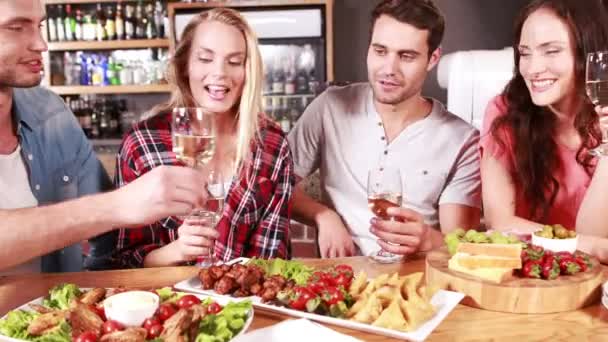 Freunde stoßen beim Essen zusammen an — Stockvideo