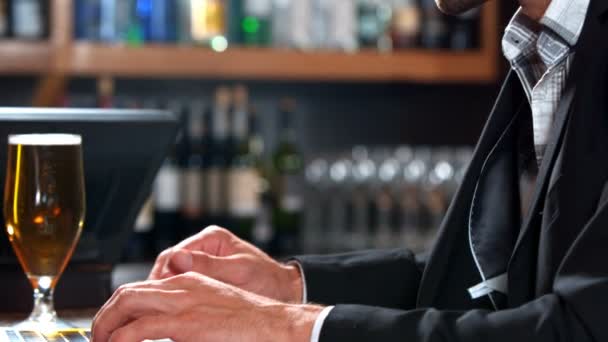 Uomo d'affari bere birra mentre si utilizza il computer portatile — Video Stock