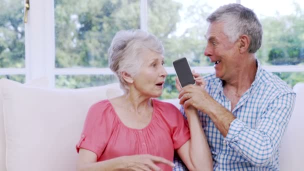 Verbaasd senior paar met smartphone — Stockvideo