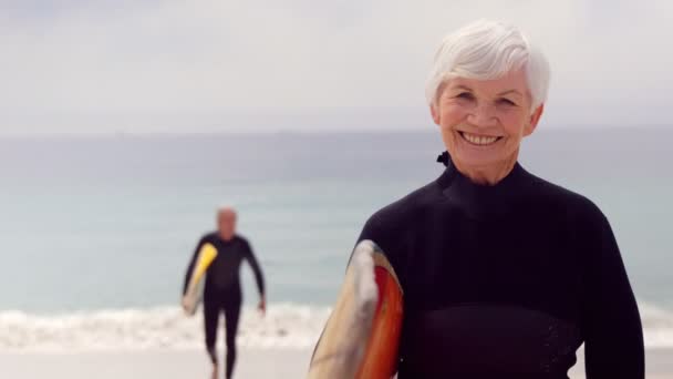 Gepensioneerde paar bedrijf surfplanken — Stockvideo