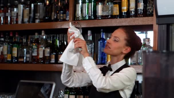 Гарненька барменка витирає келих вина — стокове відео