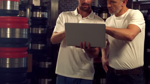 Trabalhadores da cervejaria verificando informações em um laptop — Vídeo de Stock