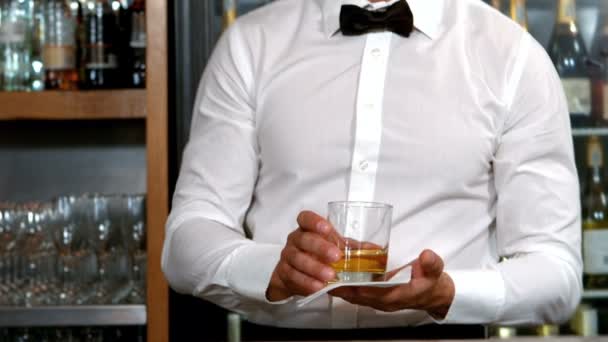 Lächelnder Barmann serviert einen Whisky — Stockvideo