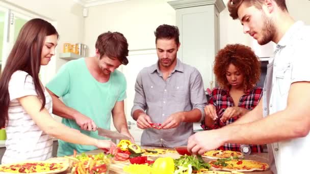 Lächelnde Freunde, die gemeinsam Pizza backen — Stockvideo