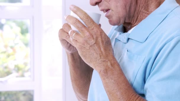 Senior man drinking by white cup — Stock Video