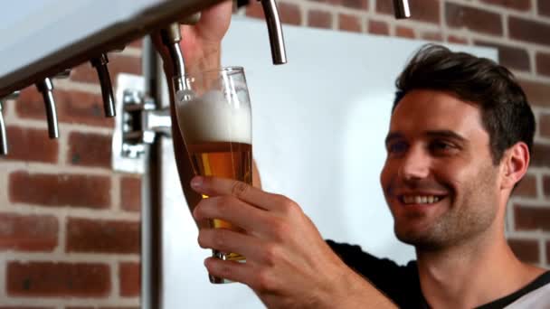 Barman sorrindo puxando um copo de cerveja — Vídeo de Stock