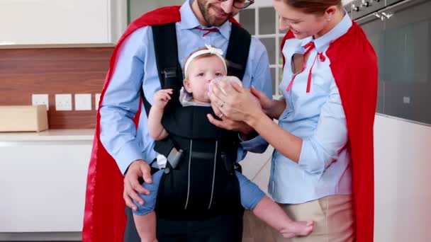 Батьки з червоним плащем годують дитину — стокове відео