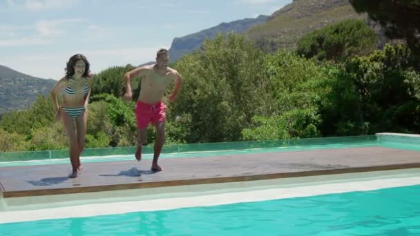 Casal pulando na piscina — Vídeo de Stock