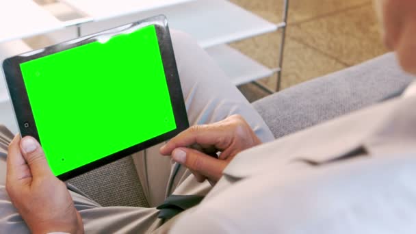 Επιχειρηματίας χρησιμοποιώντας tablet που κάθεται στον καναπέ — Αρχείο Βίντεο