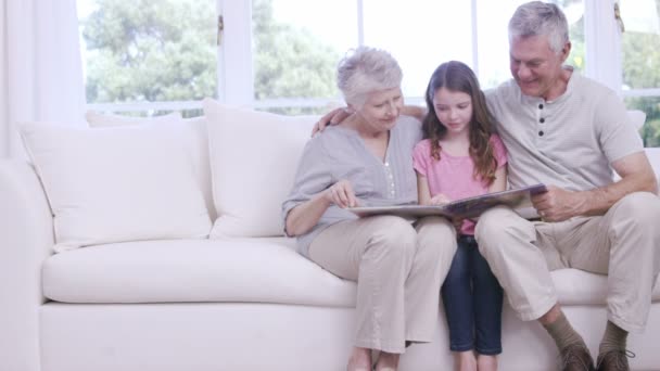 Großeltern lesen Buch mit Enkelin — Stockvideo