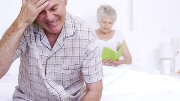 Suffering senior man sitting on bed — Stock Video