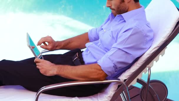 Homem bonito usando tablet na cadeira deck — Vídeo de Stock