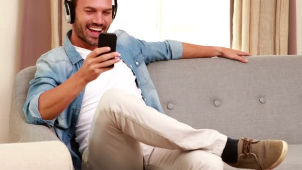 Hombre escuchando música y usando smartphone — Vídeos de Stock