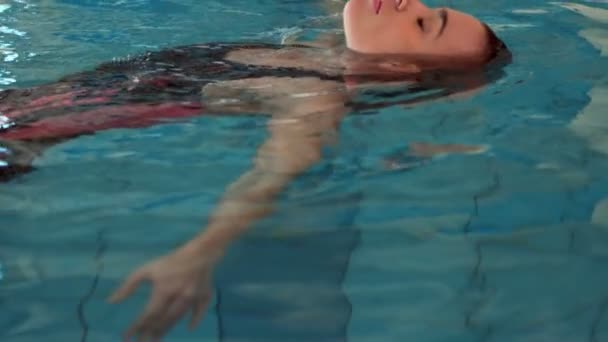 Ελκυστική γυναίκα χαλαρώνοντας στην πισίνα — Αρχείο Βίντεο