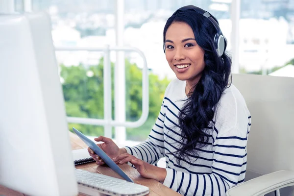 Mulher asiática com fones de ouvido usando tablet — Fotografia de Stock