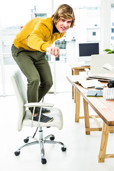 Hipster businessman standing on chair — Stock Photo, Image