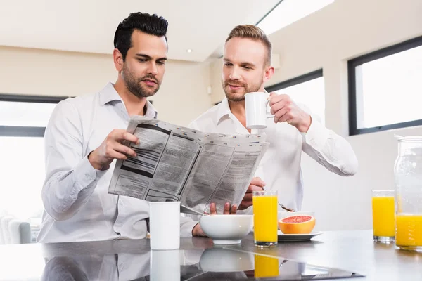 Pareja gay leyendo periódico — Foto de Stock