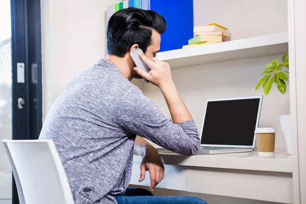 Upptagen man använder smartphone och laptop — Stockfoto