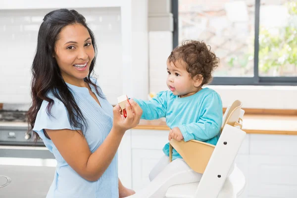 Felice bruna nutrire il suo bambino — Foto Stock