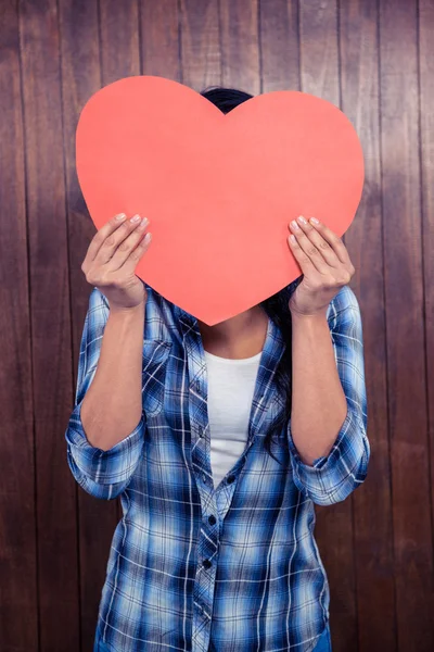 Mujer escondiendo la cara detrás del corazón de papel — Foto de Stock