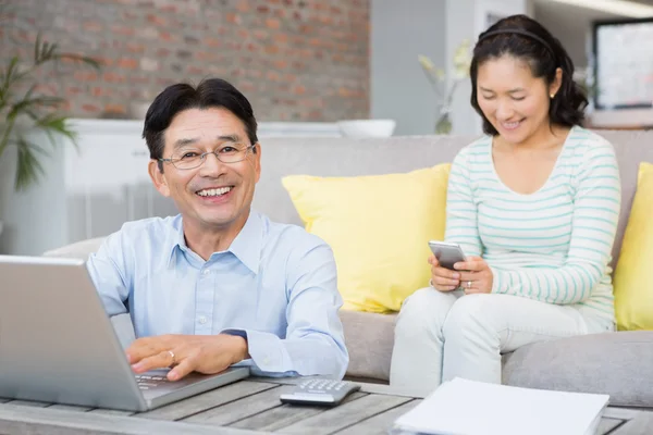 Homem sorridente contando contas — Fotografia de Stock