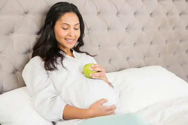 Schwangere Brünette hält Apfel — Stockfoto