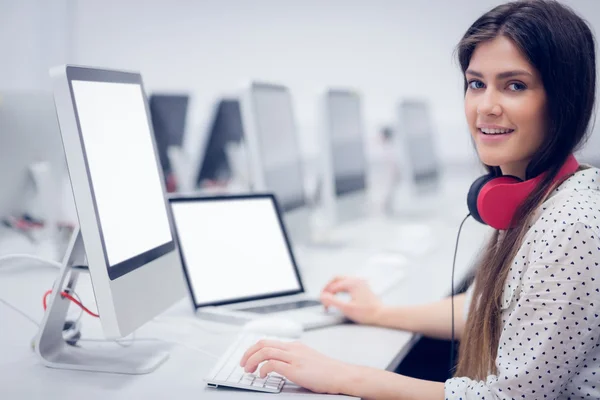 Estudiante sonriente usando laptop y computadora —  Fotos de Stock