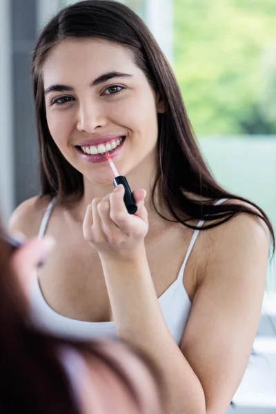 Brunette applying lip gloss — Stock Photo, Image