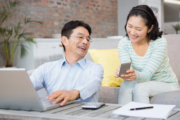 Woman showing smartphone to her husband — 图库照片