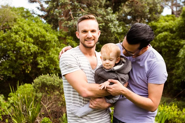 Smiling gay couple with child