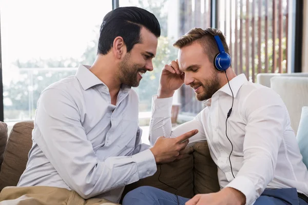 Homosexuella par avkopplande i vardagsrum — Stockfoto