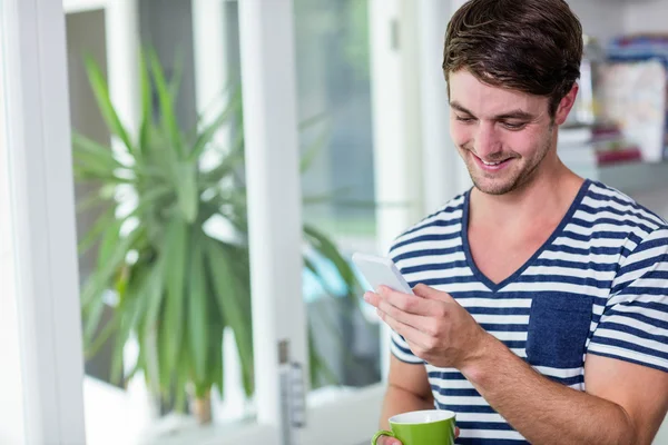 Un homme souriant fixe son smartphone — Photo