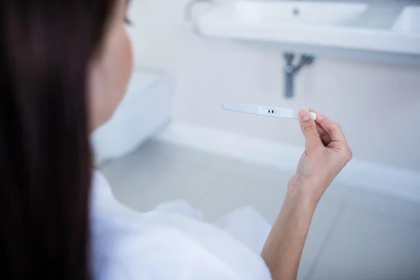 Mujer mirando la prueba de embarazo — Foto de Stock