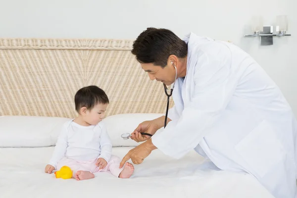Cute baby being visited by doctor — 图库照片