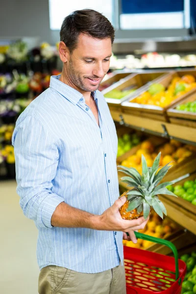 Ember nézi egy ananász — Stock Fotó
