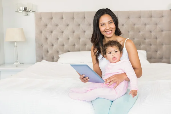 Brunett hålla barnet och med hjälp av Tablet PC — Stockfoto